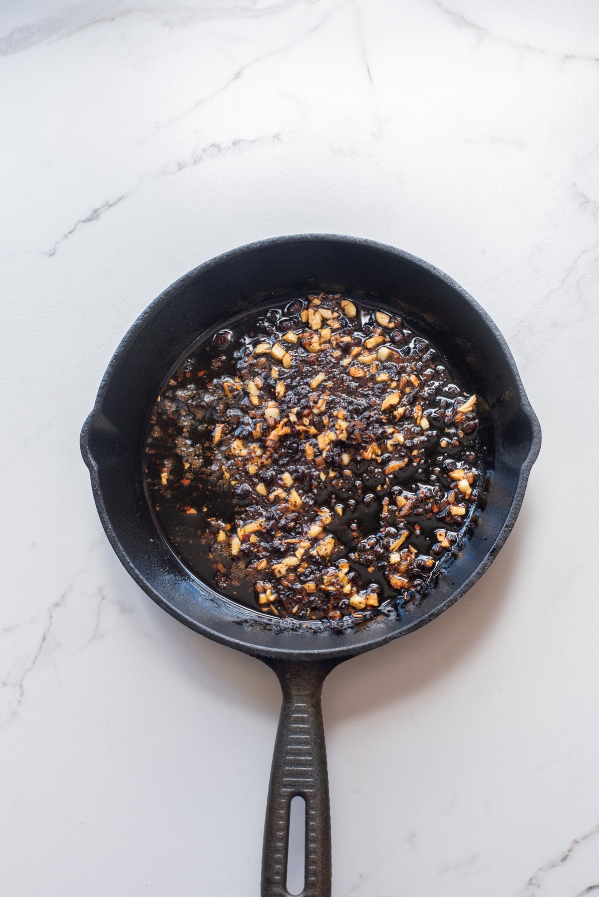 An overhead image of adding the spicy fermented bean paste.