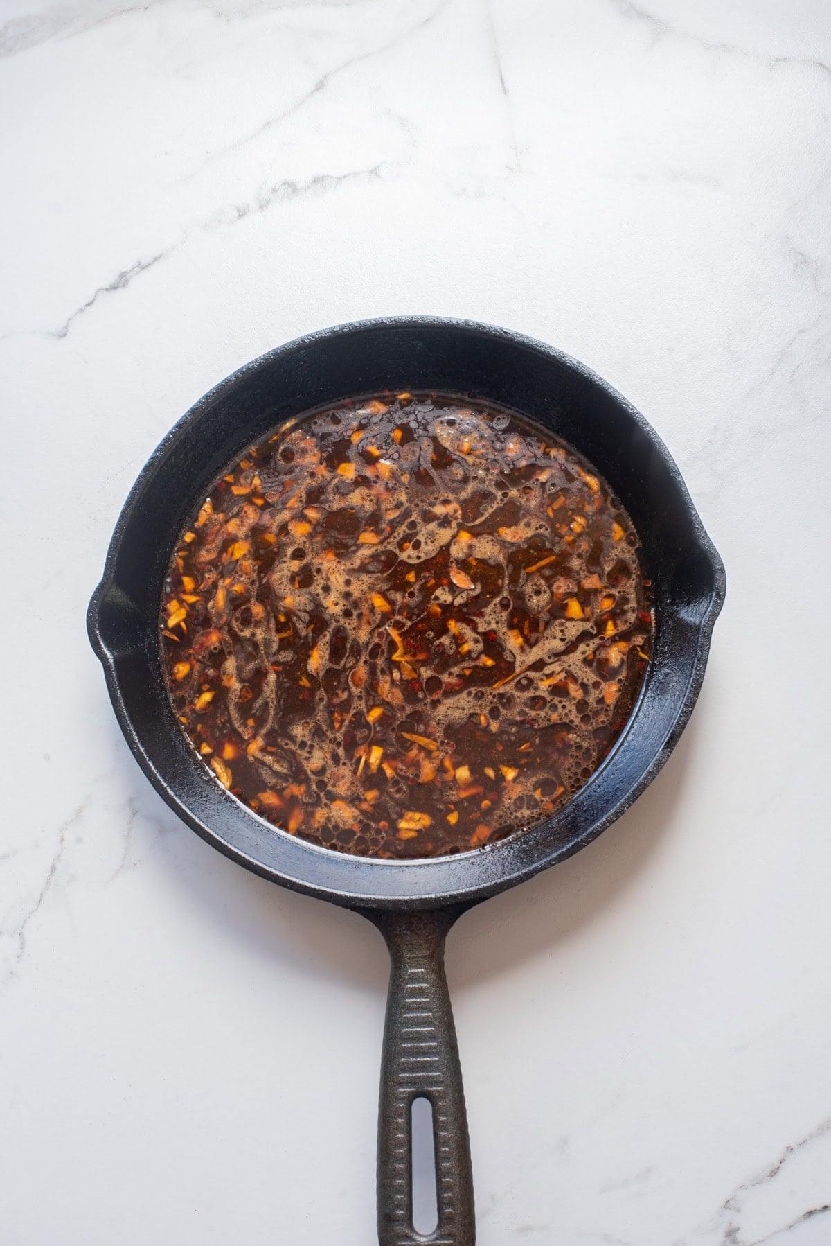 An overhead image of adding the soy sauce mixture to the skillet.