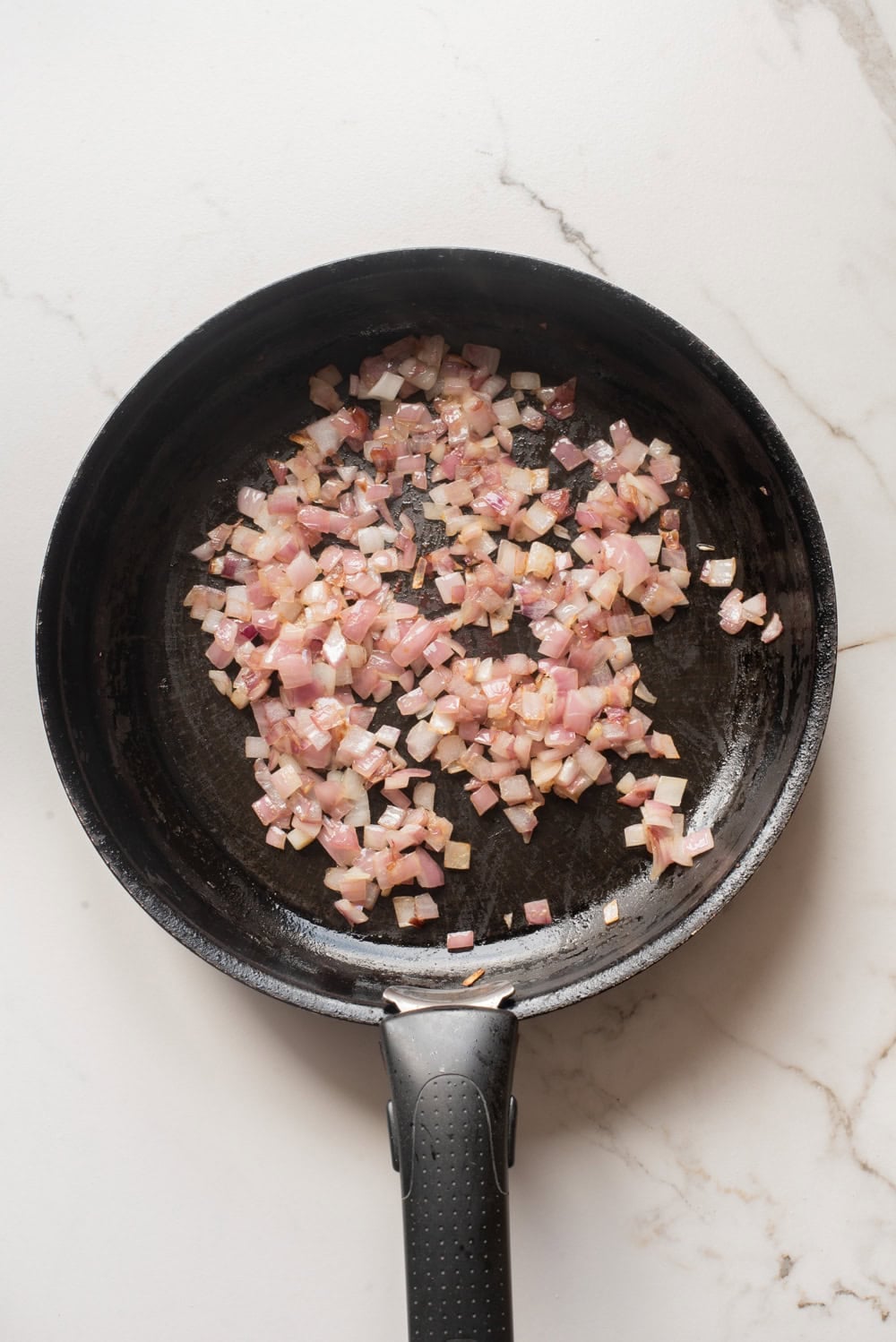 Onion cooking in a skillet before adding the aromatics.