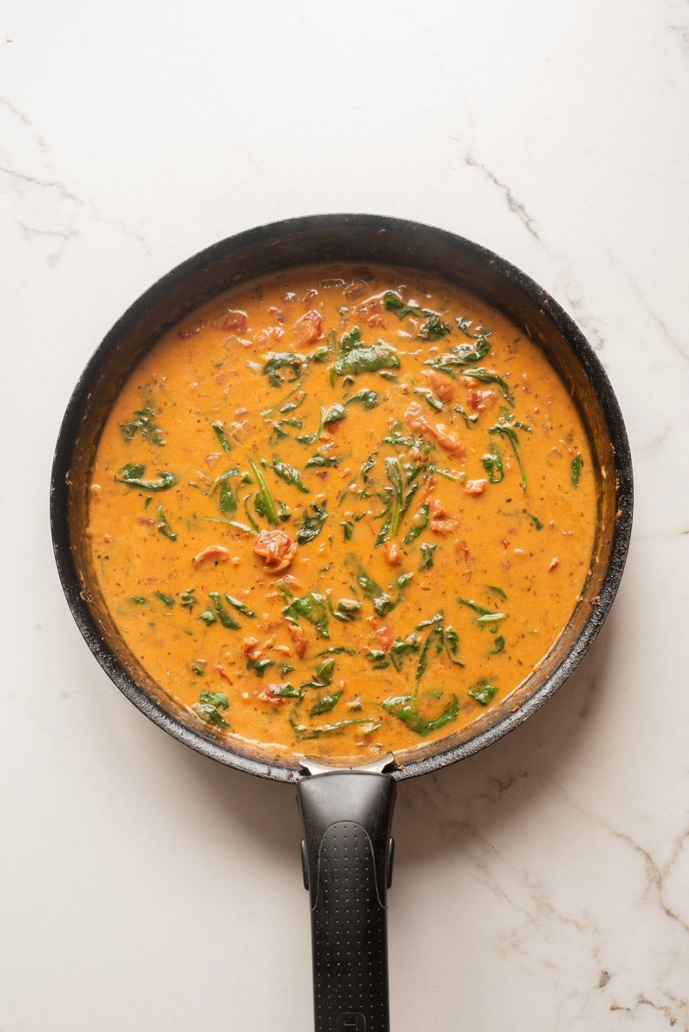 Spinach stirred into the creamy sun-dried tomato sauce.