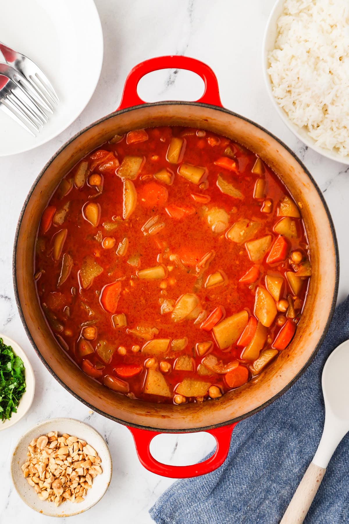An overhead image of vegan massaman curry in a pot ready to be served.
