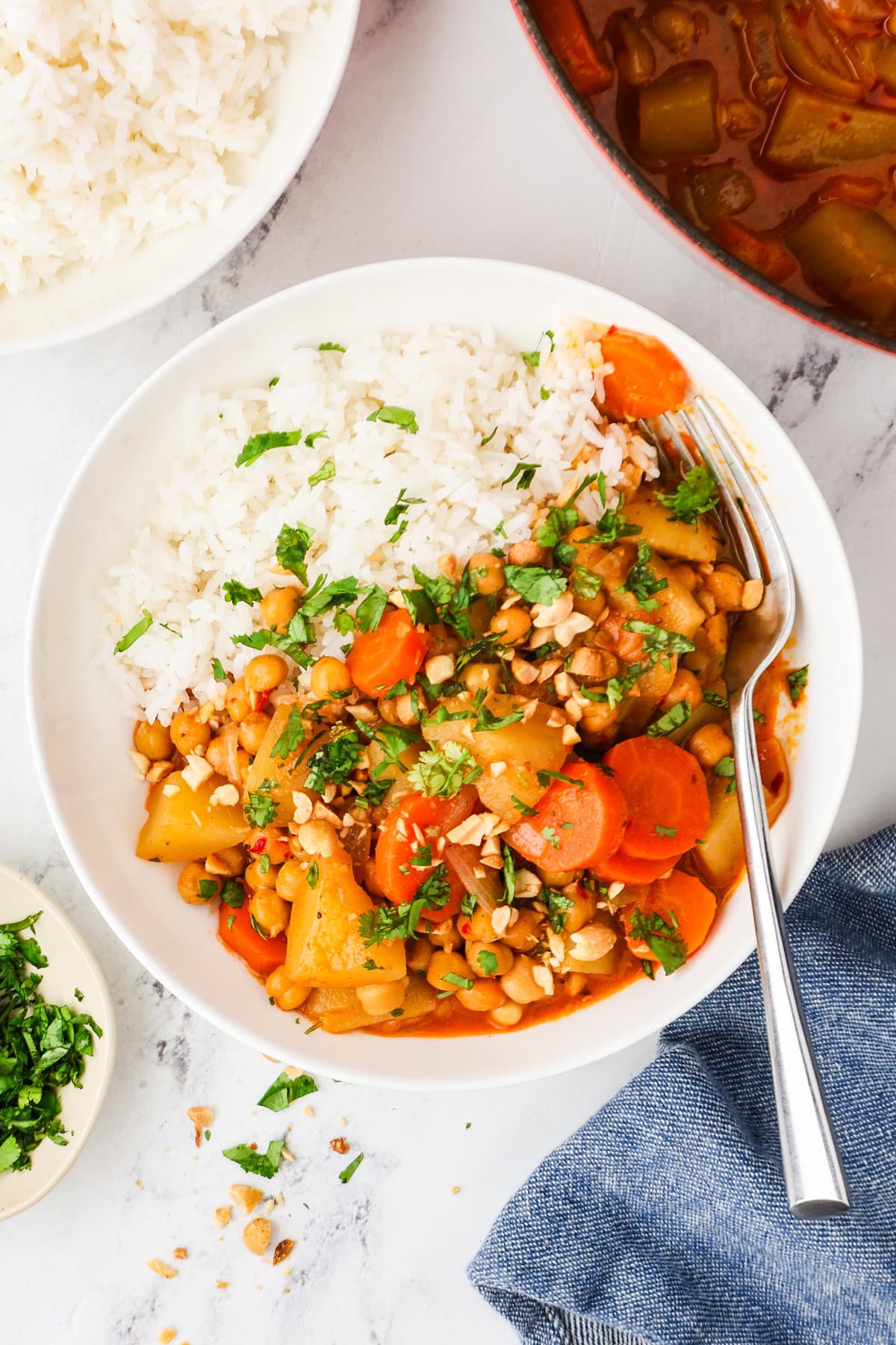 An overhead image of vegan massaman curry served on a plate with rice.