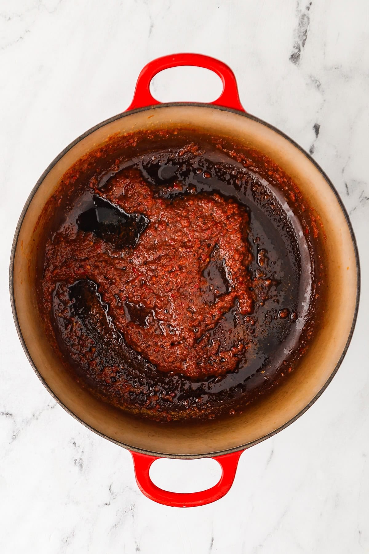 An overhead image of adding the massaman curry paste into the pot.