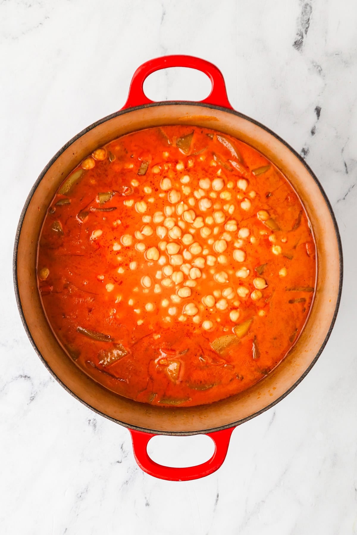 An overhead image of adding chickpeas to the pot.