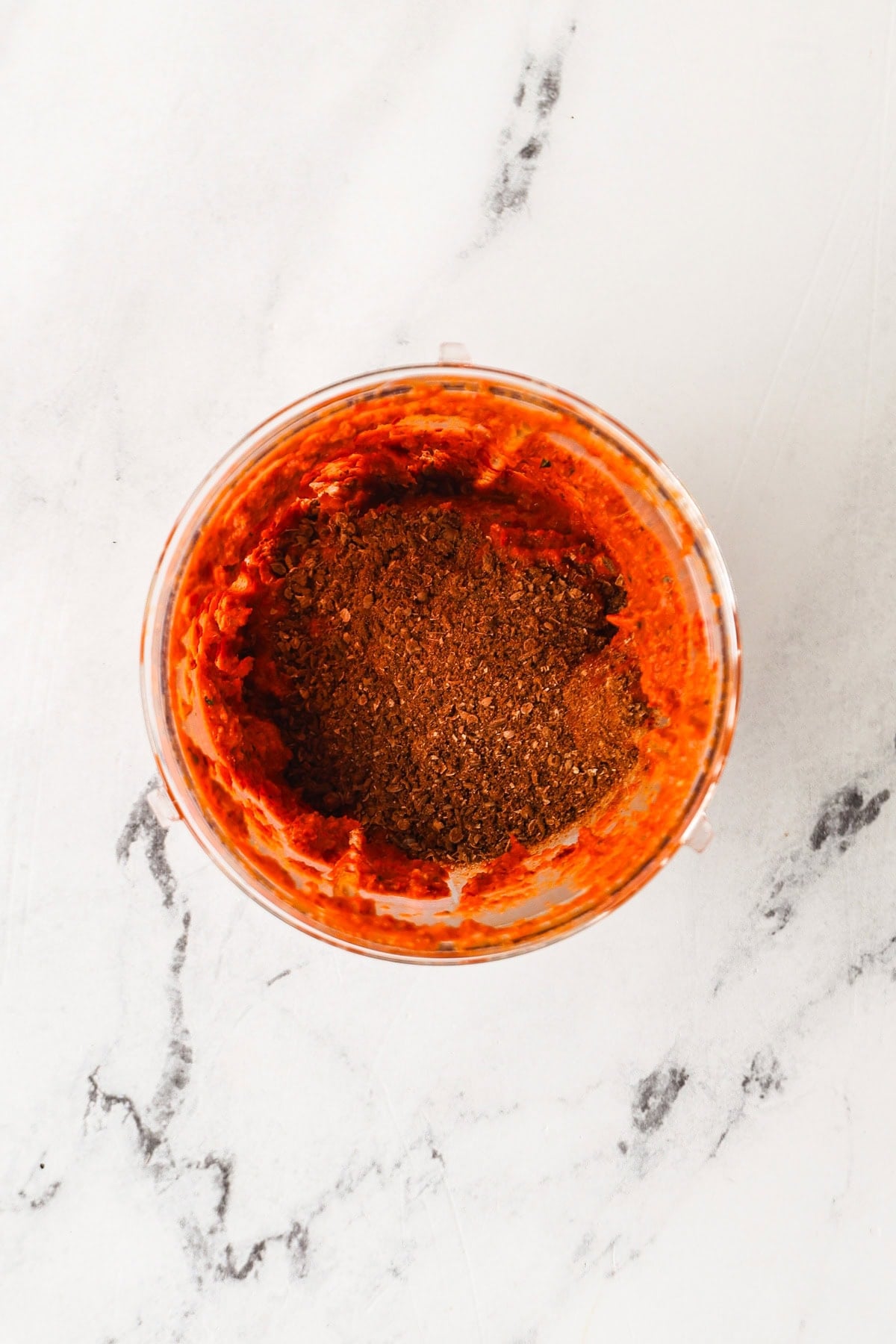 Ground spices added on top of blended curry paste in a food processor.