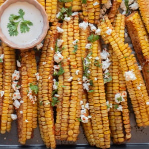 An overhead image of corn ribs with cheese sauce on the side.