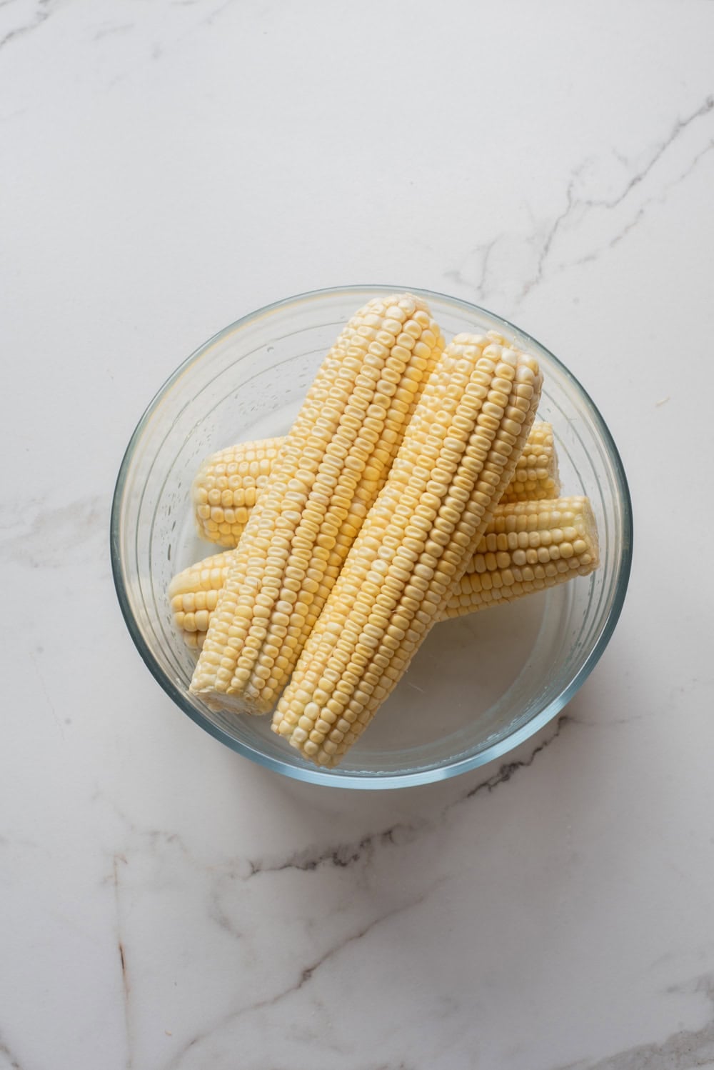An overhead image of microwaving the corn to soften.