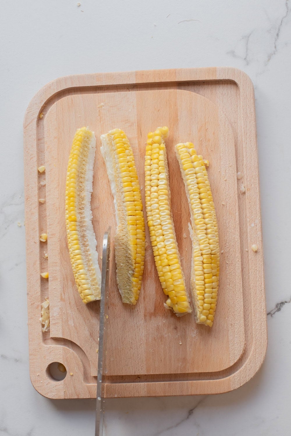 An overhead image of cutting the corn into ribs.