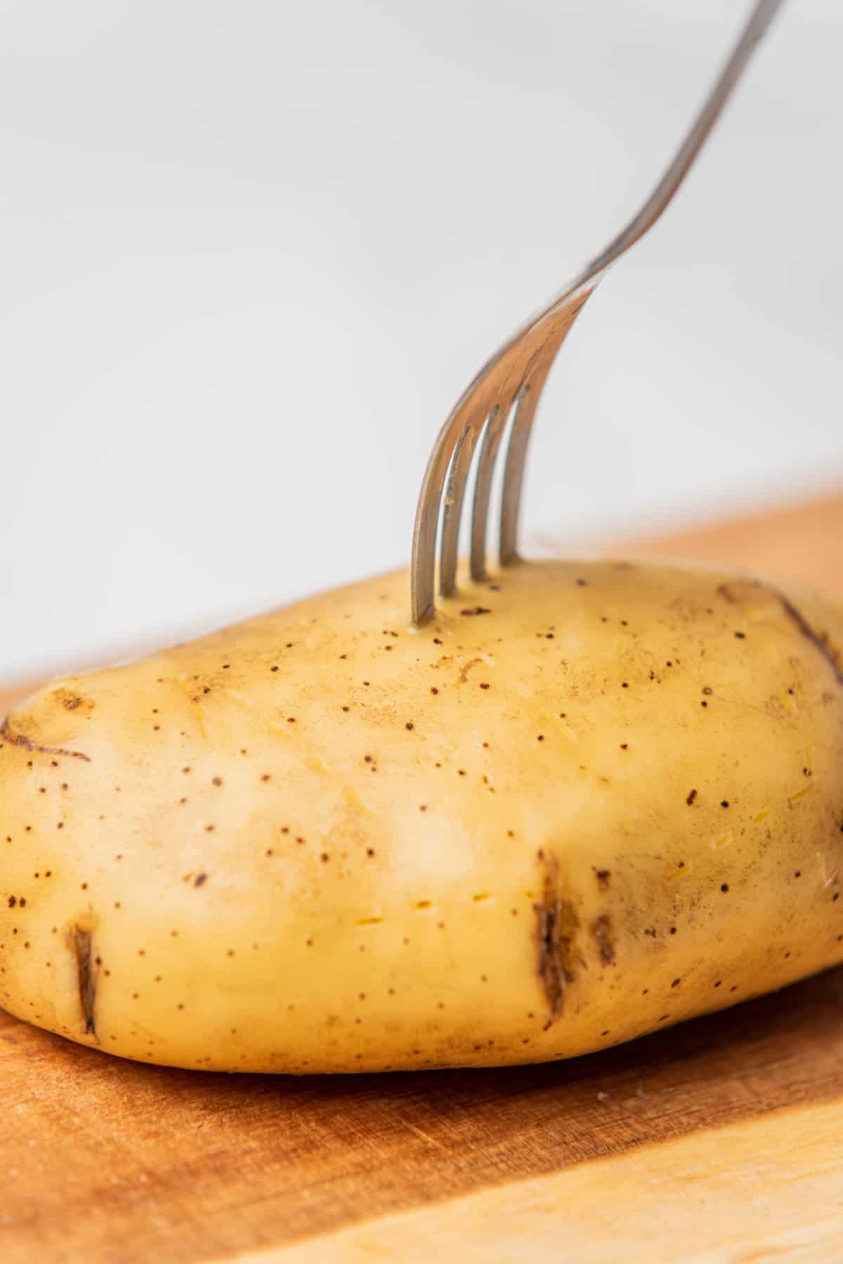 A photo of a potato being pierced with a fork