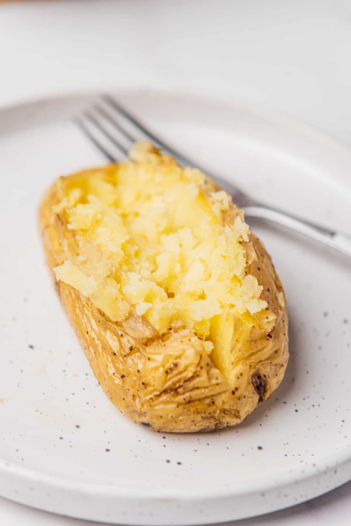 An image of microwave baked potato with a fark behind it