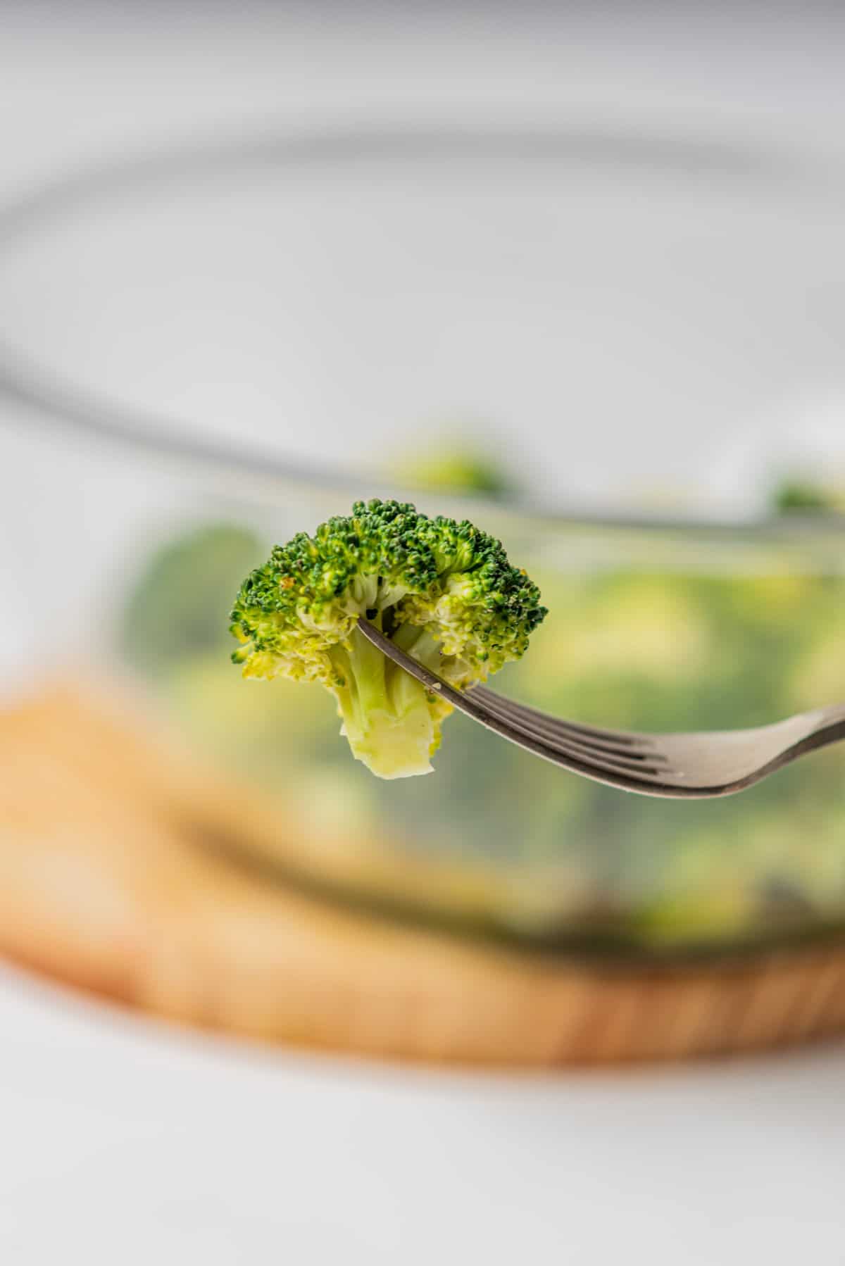 A close up image of a broccoli pierced by a fork