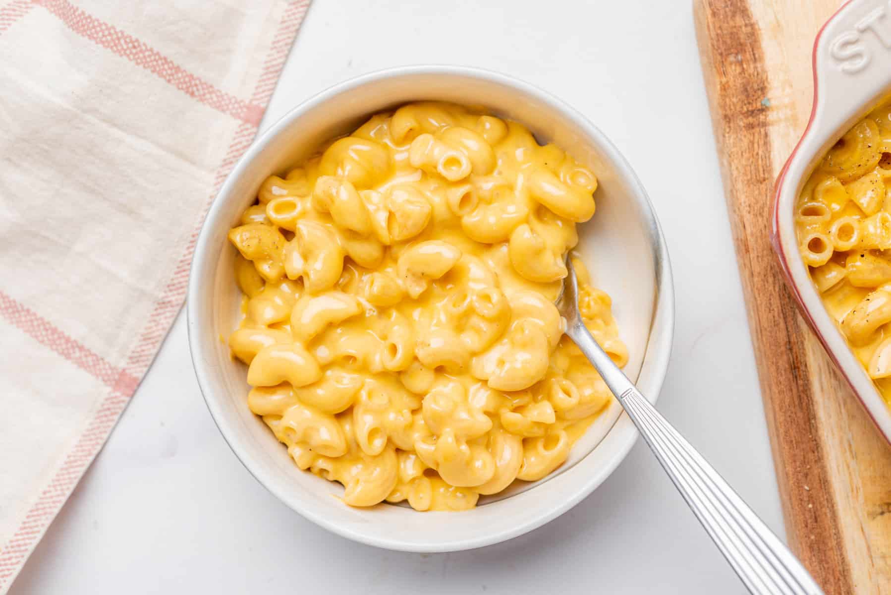 An overhead image of microwave mac and cheese in a bowl with a spoon.