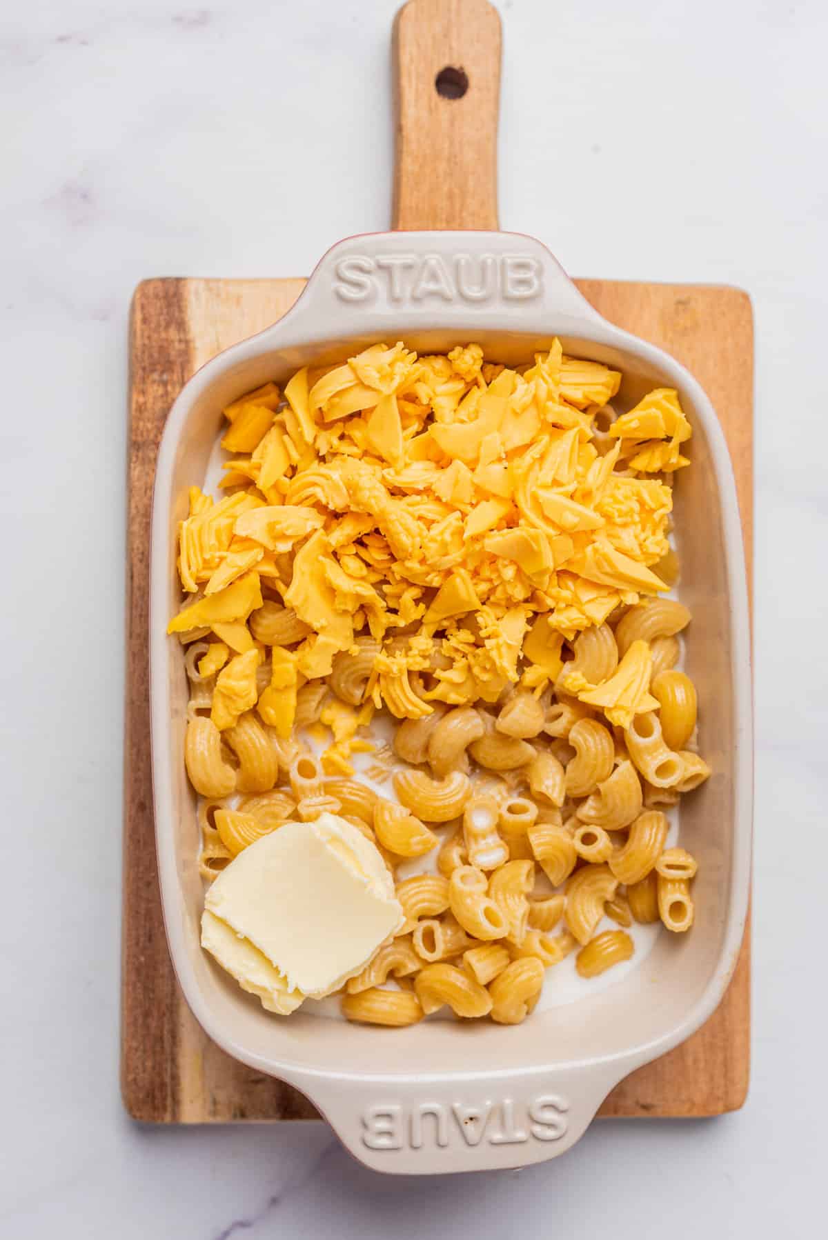 An image of cooked elbow macaroni with butter in a microwave safe dish.