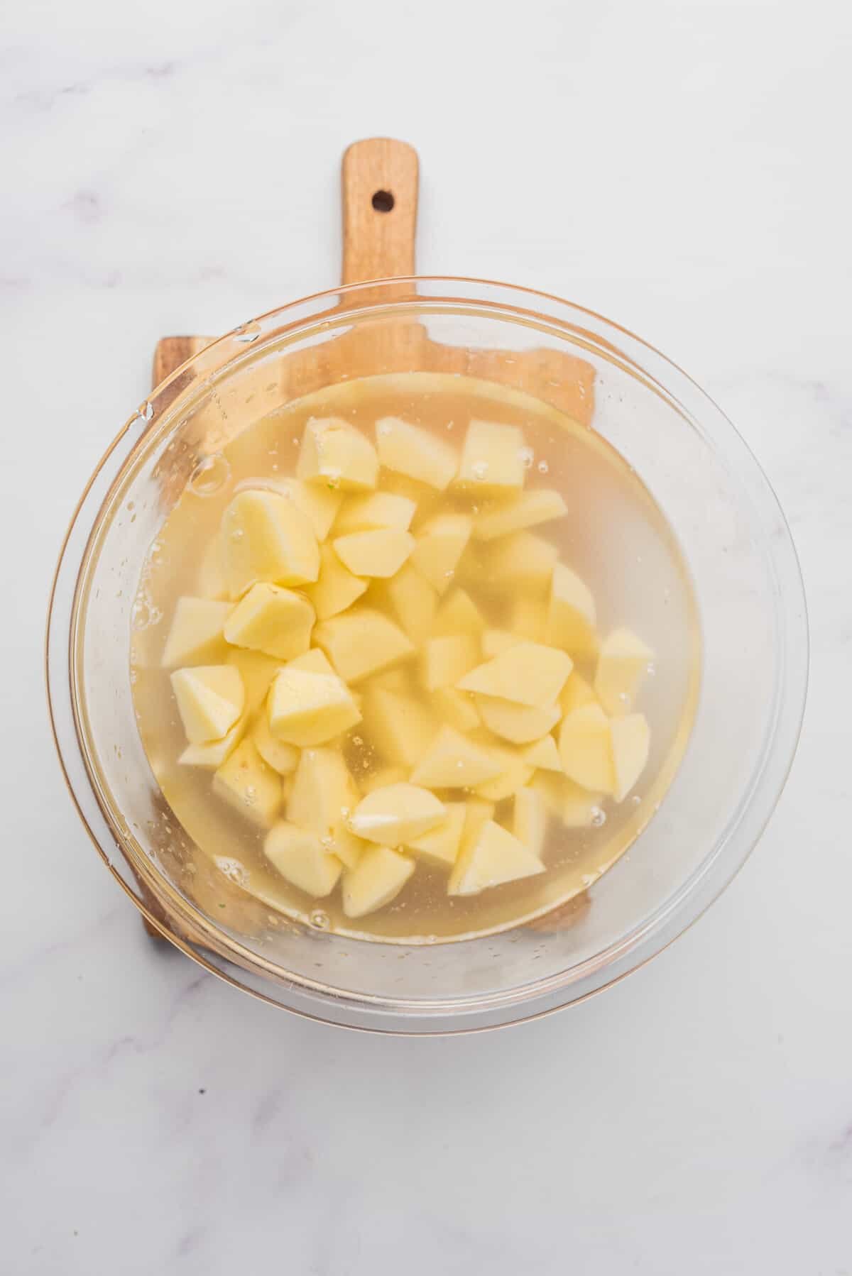 An overhead image of potato cubes in a bowl.