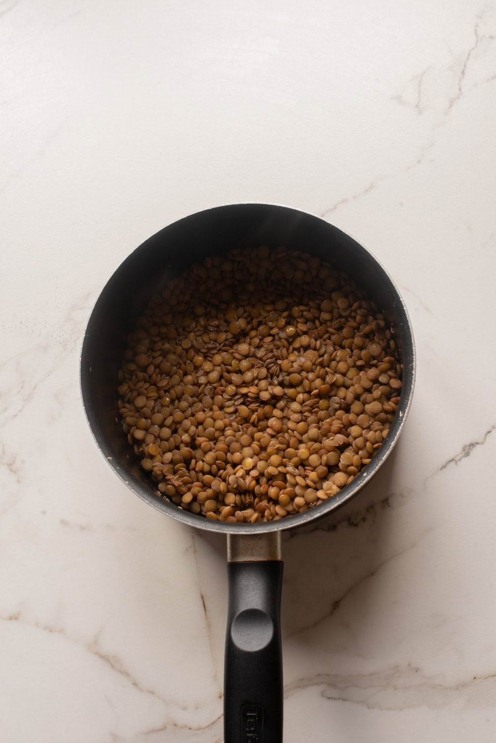 Cooked lentils in a saucepan.