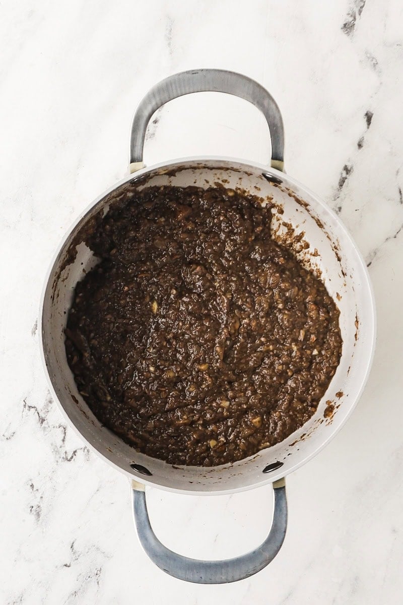 Sherry added in the mushroom mixture for mushroom gravy in a saucepan.