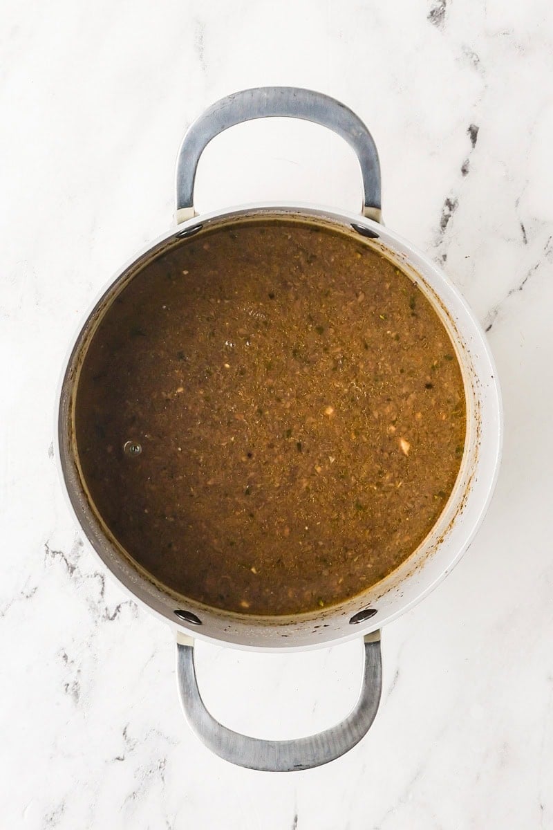 Vegan mushroom gravy simmering in a saucepan.