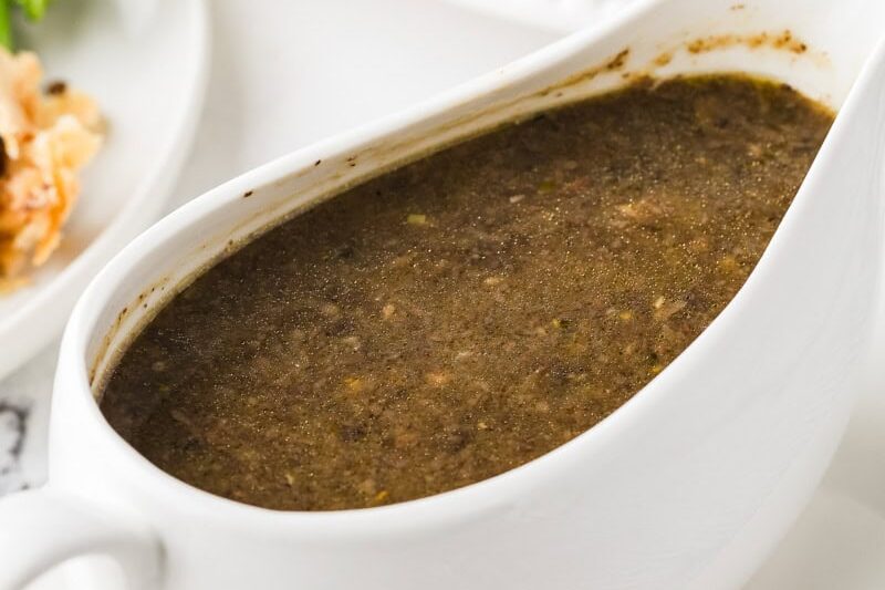 Rich vegan mushroom gravy in a white gravy boat.