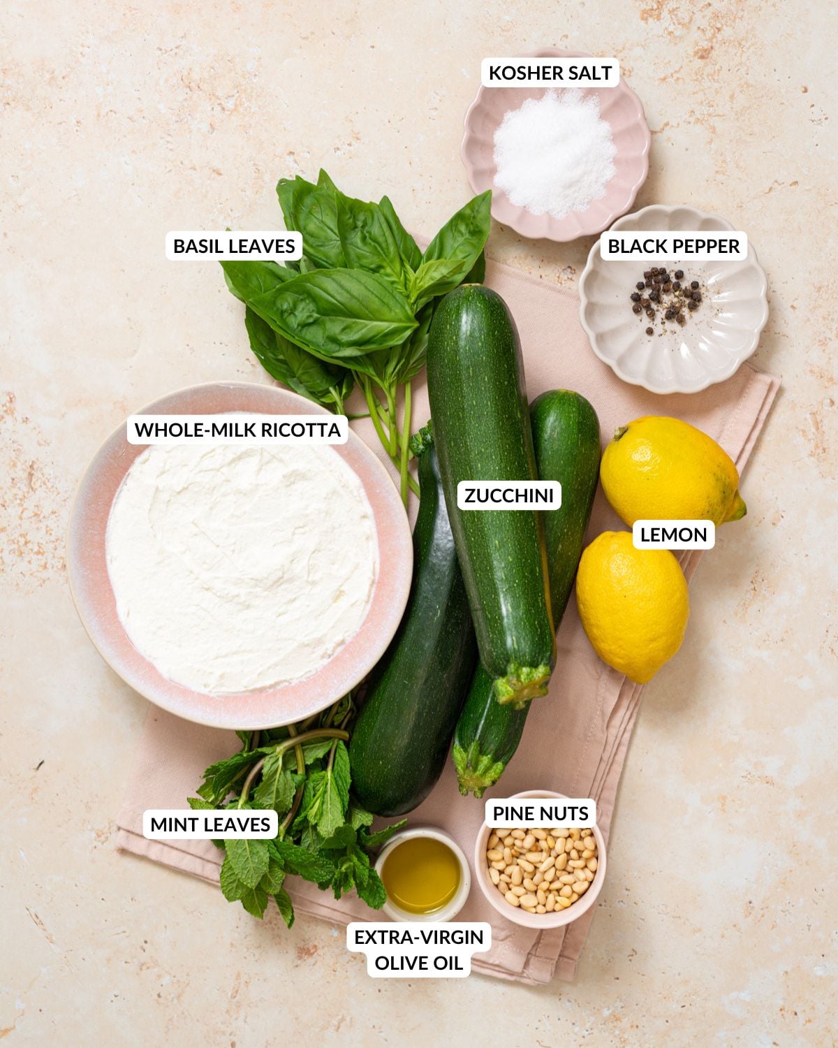 Ingredients for no-cook zucchini ribbon salad arranged on a light surface.