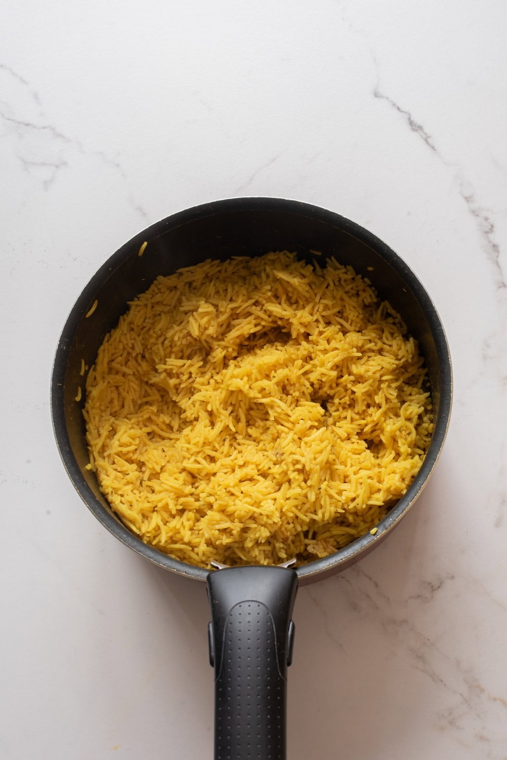 Cooked yellow seasoned rice in a pot.