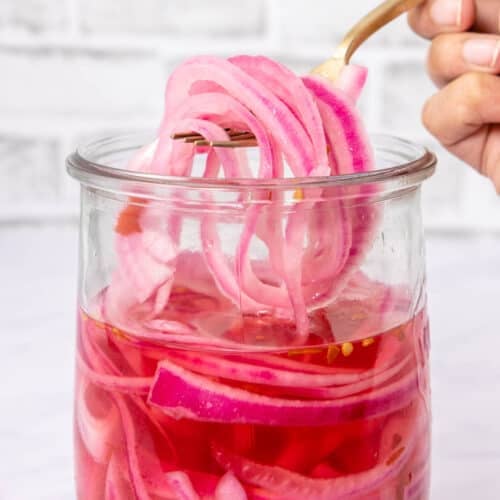 Close up of pickled onions on a fork