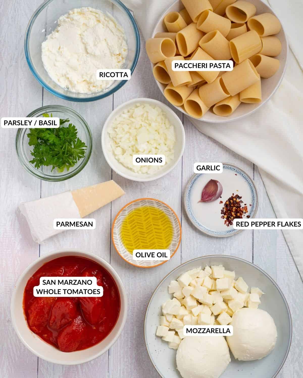 Overhead image of ingredients for paccheri al forno with labeled ingredients - check recipe card for details