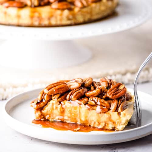 Close up of pecan pie cheesecake with the full cheesecake in the back.