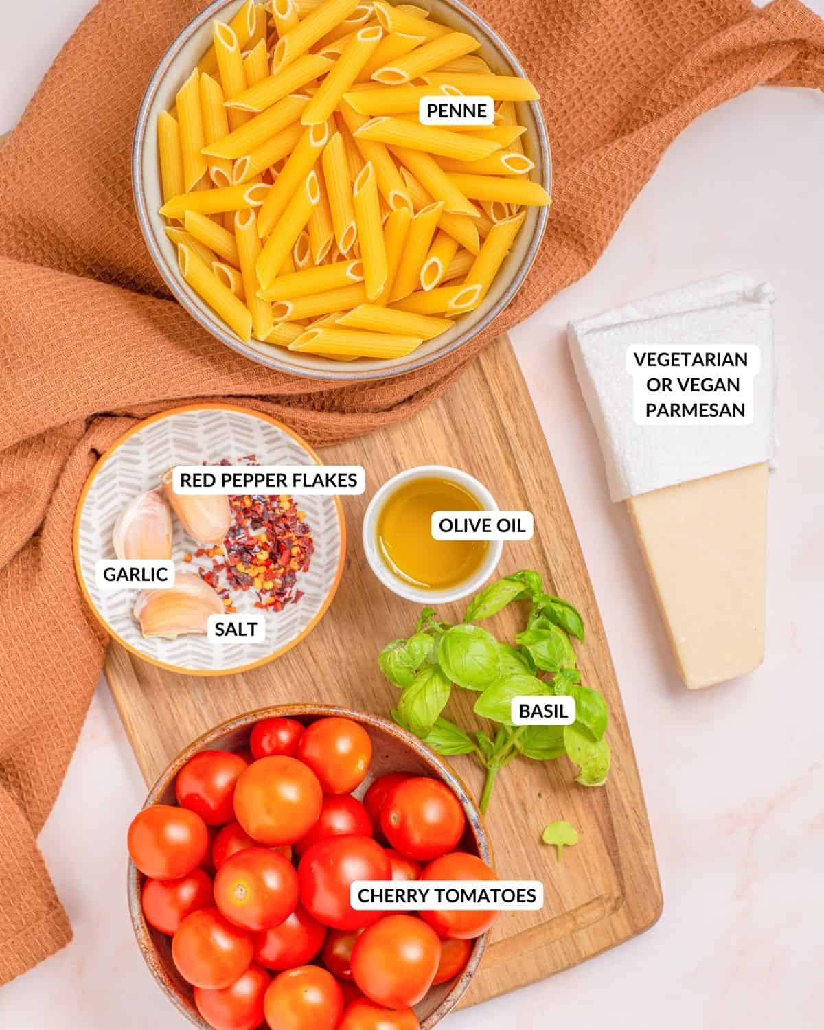 Overhead view of labeled ingredients for penne pomodoro - check recipe card for details.