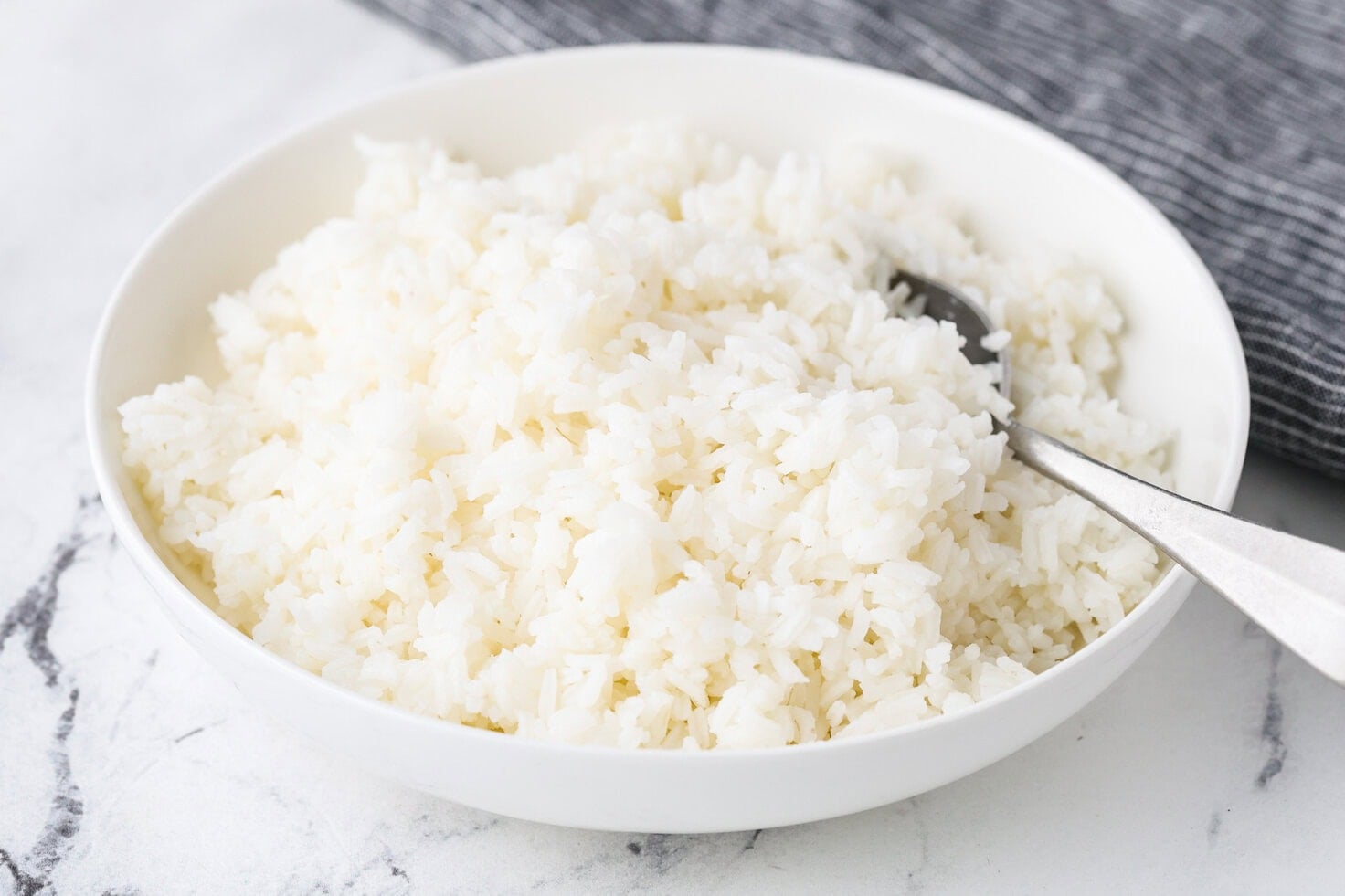 A close up image of cooked jasmine rice in a serving bowl.