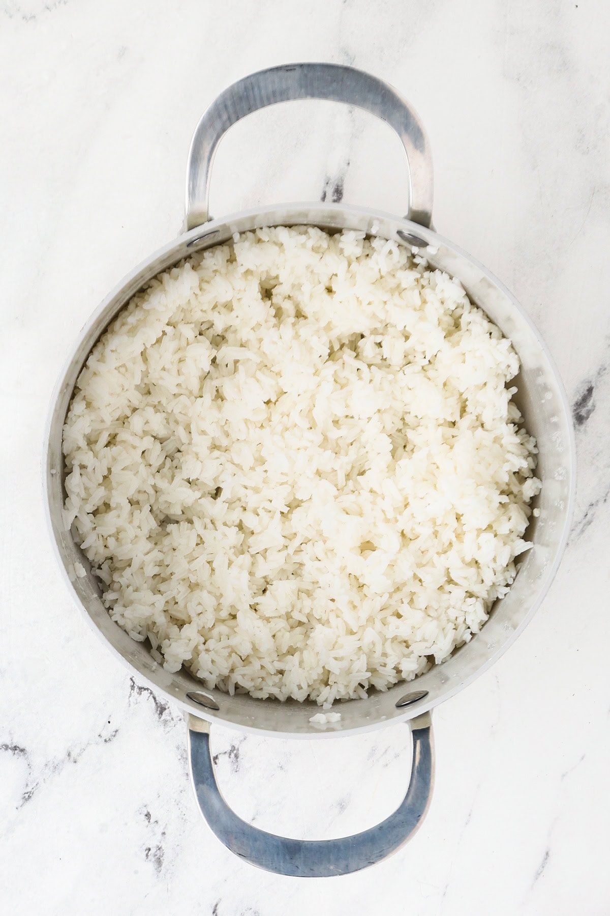 An overhead image of the cooked jasmine rice in a saucepan.