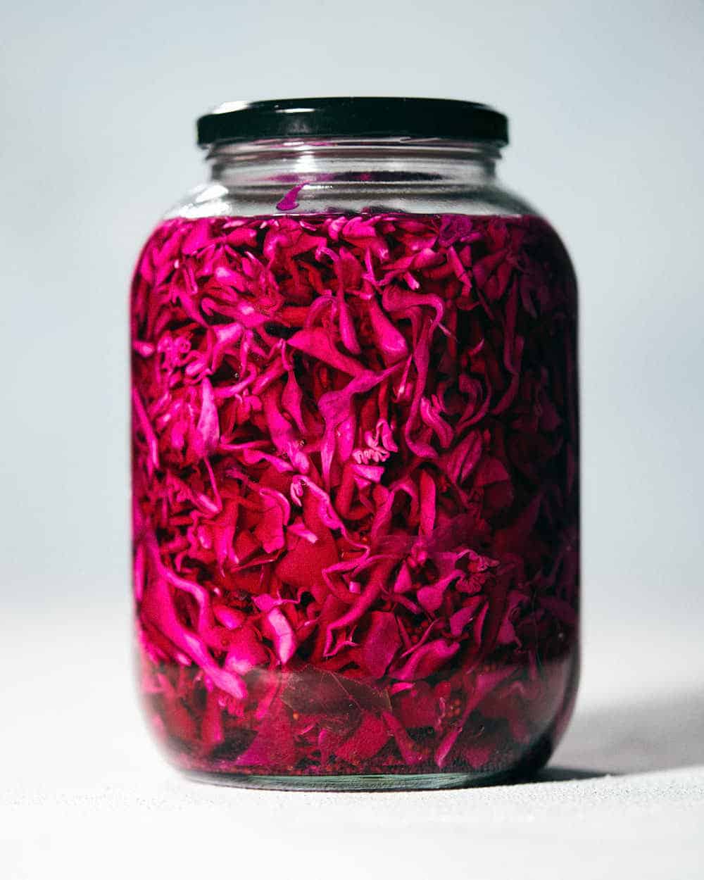A straight view of pickled red cabbage placed in a jar.