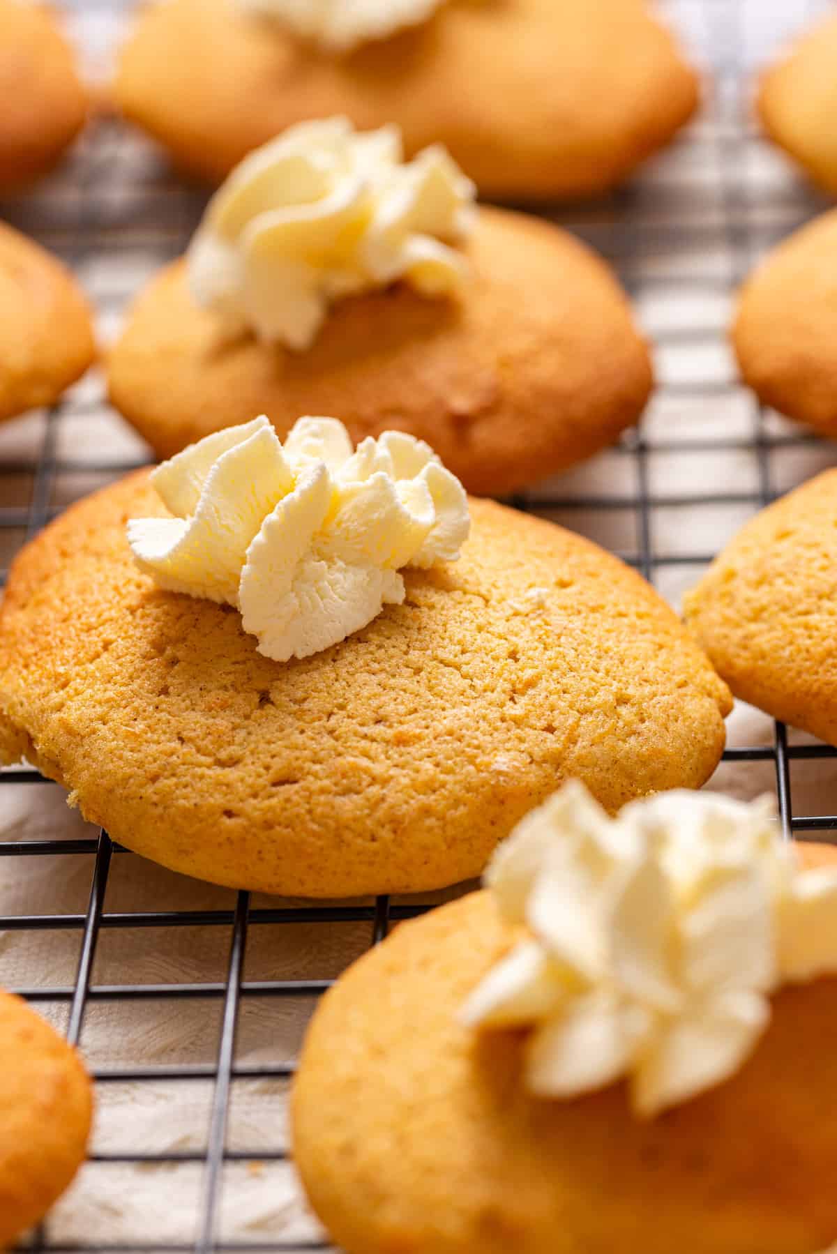 A close up image of pumpkin pie cookies with whipped cream on top.