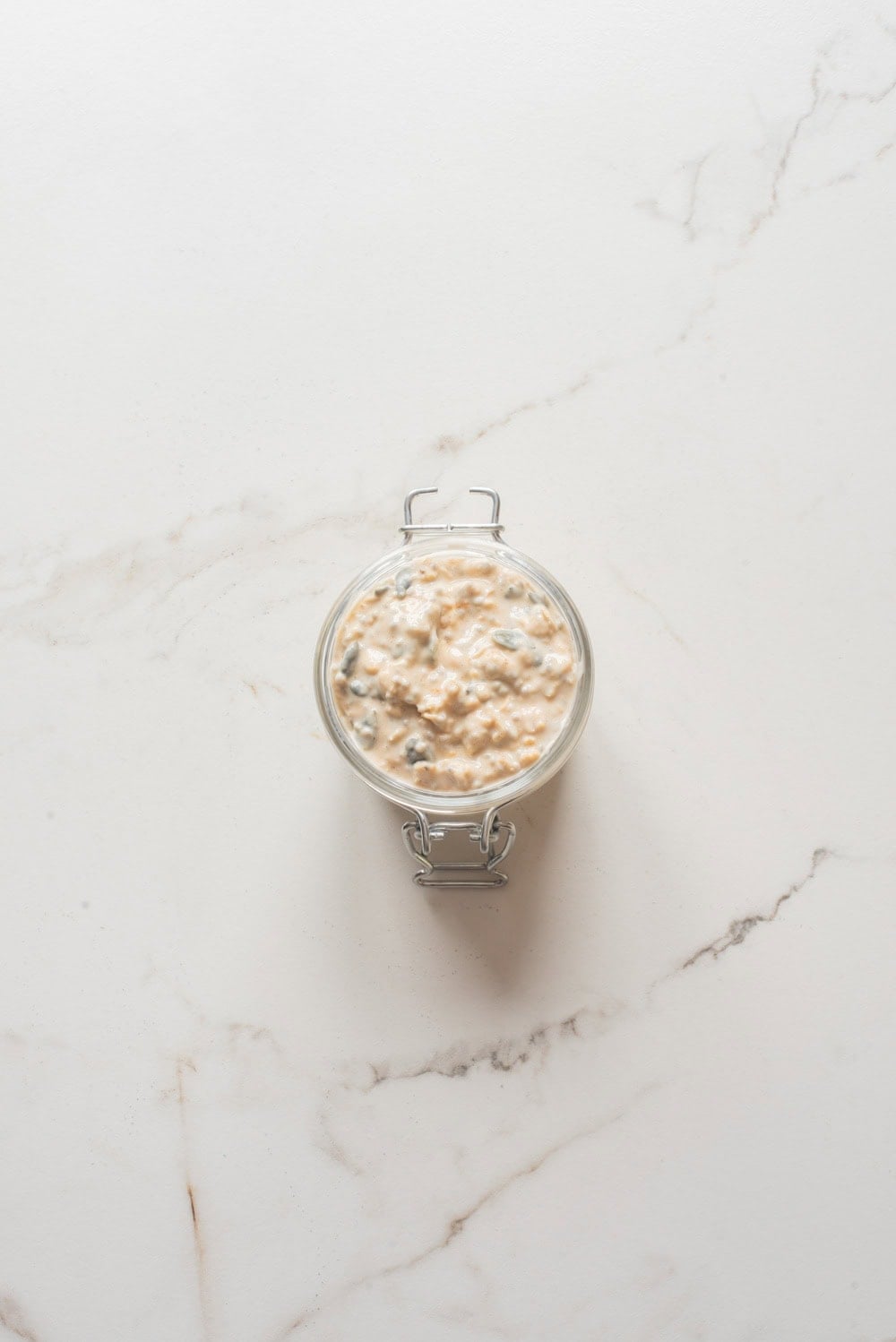 Overhead image of pumpkin pie overnight oats without toppings in a jar.