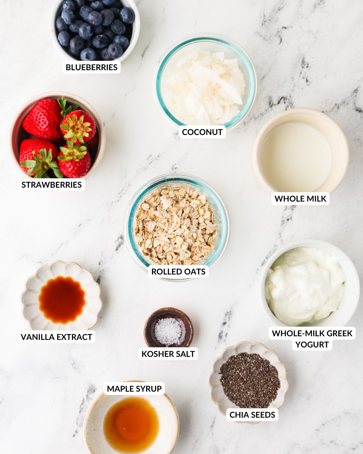 Ingredients for Red, White & Blue Overnight Oats arranged on a marble surface.