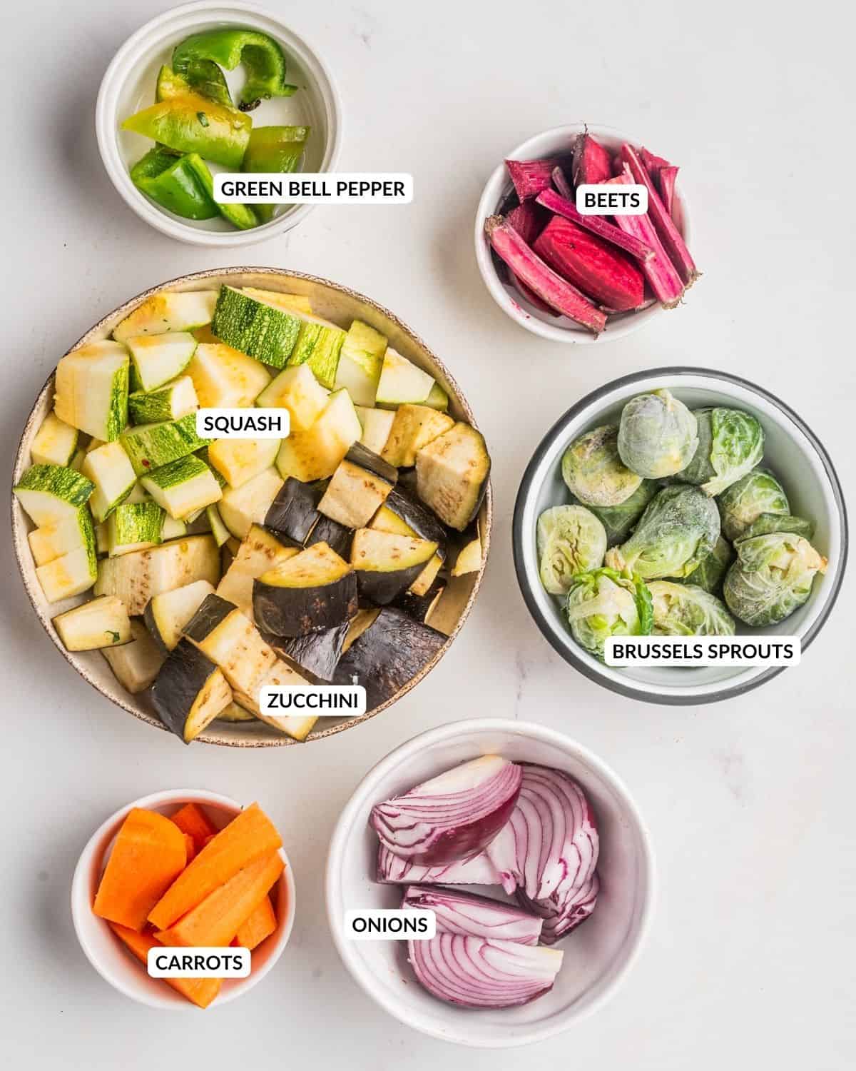 An overhead image of roasted vegetable salad ingredients with labels.