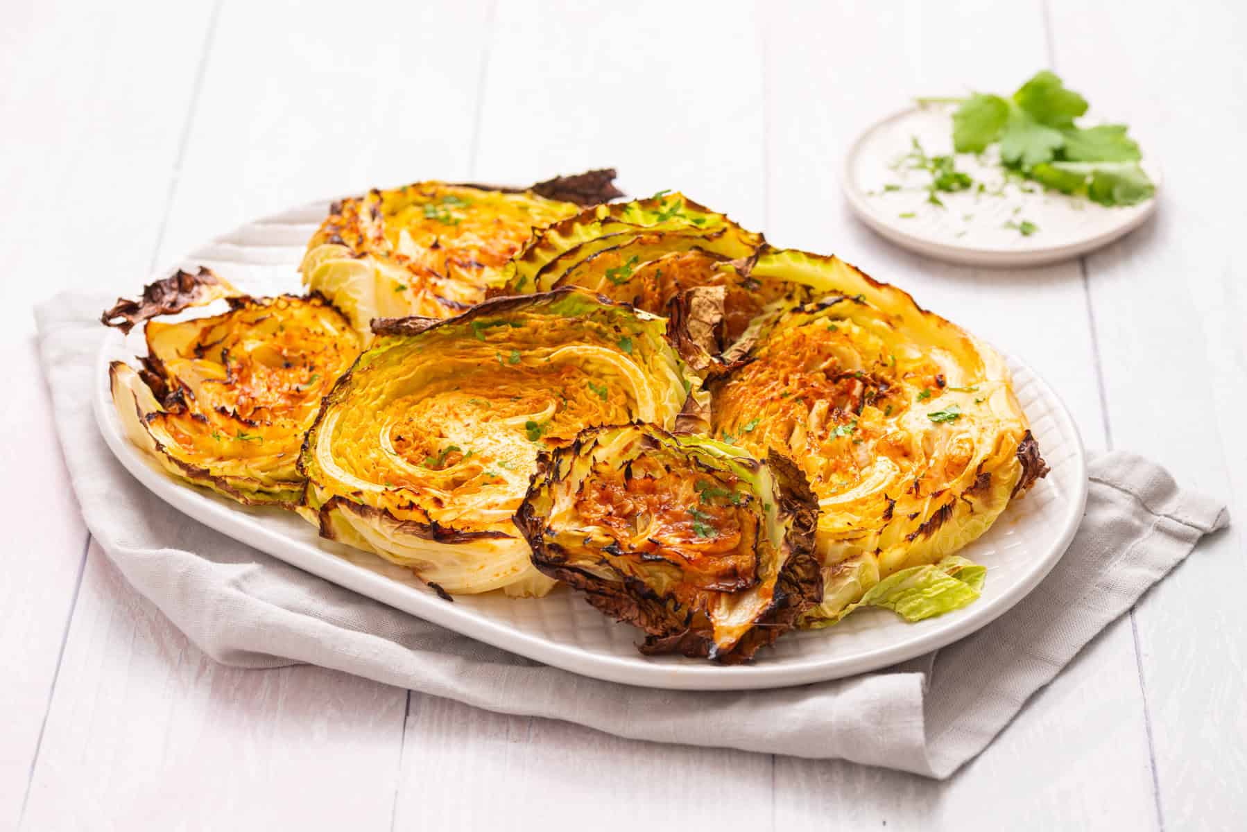 An image of roasted cabbage steaks on a serving plate.