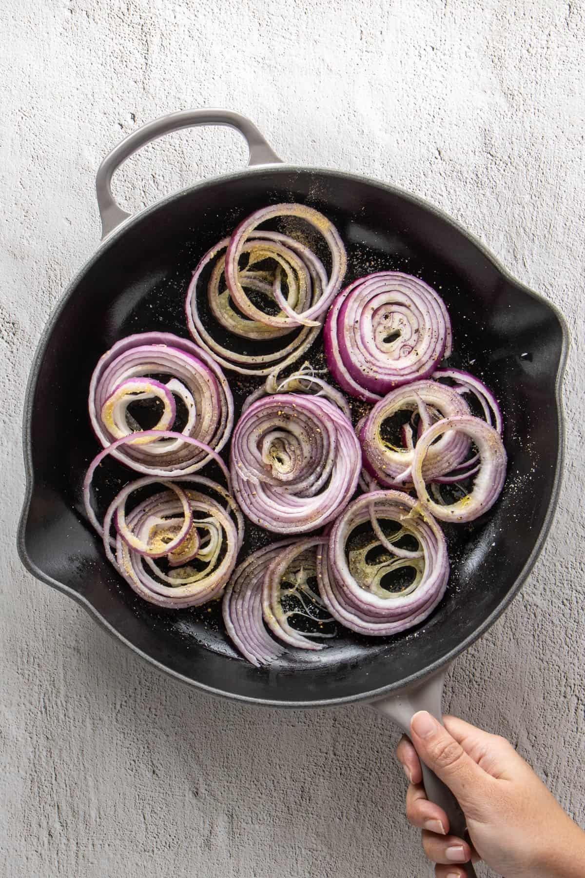 Roasted red onions in skillet halfway through the process