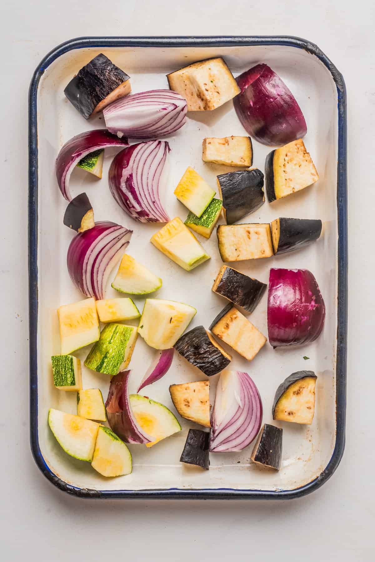 An overhead image of chopped vegetables in a baking dish.