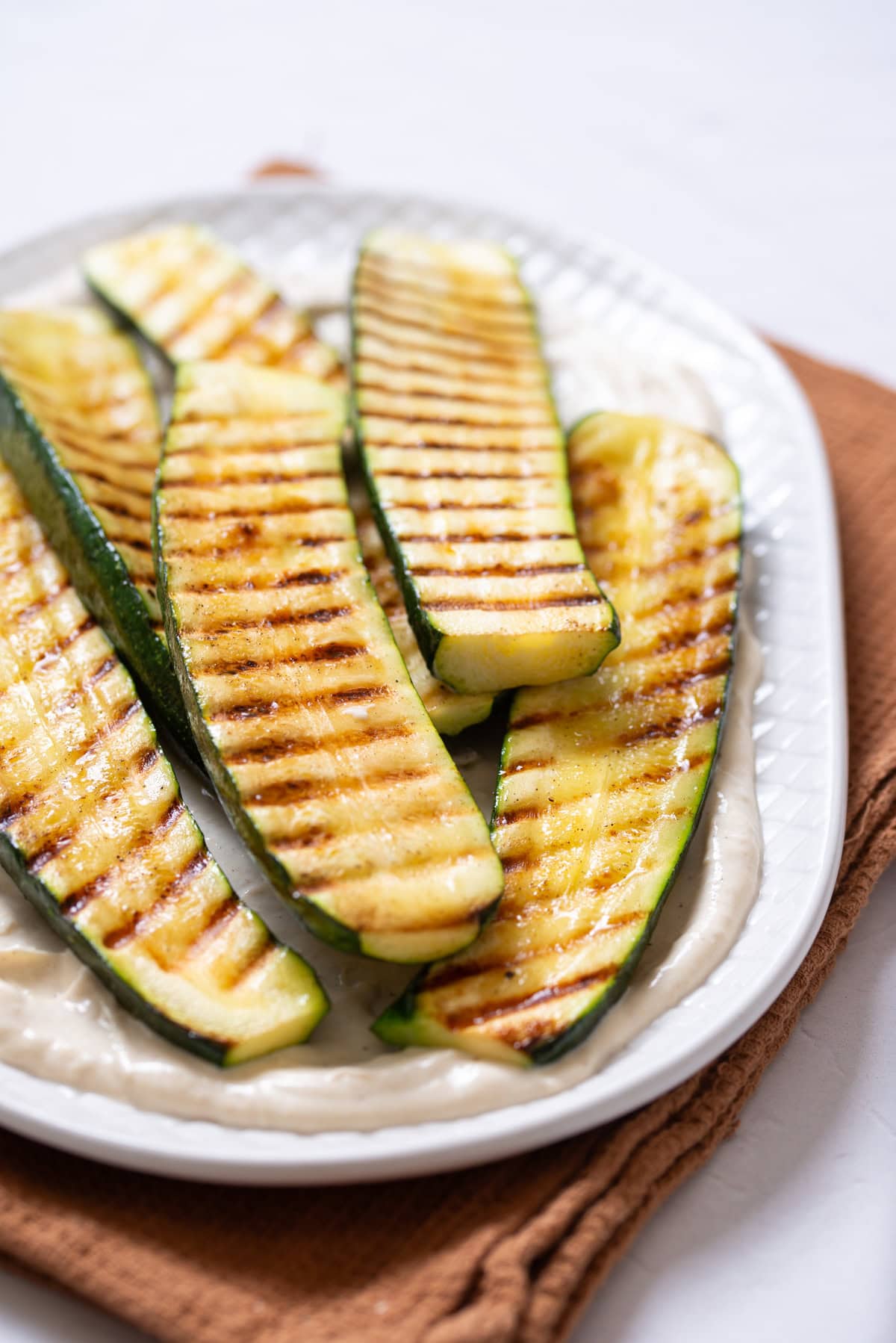 A close up image of grilled zucchini on a platter.