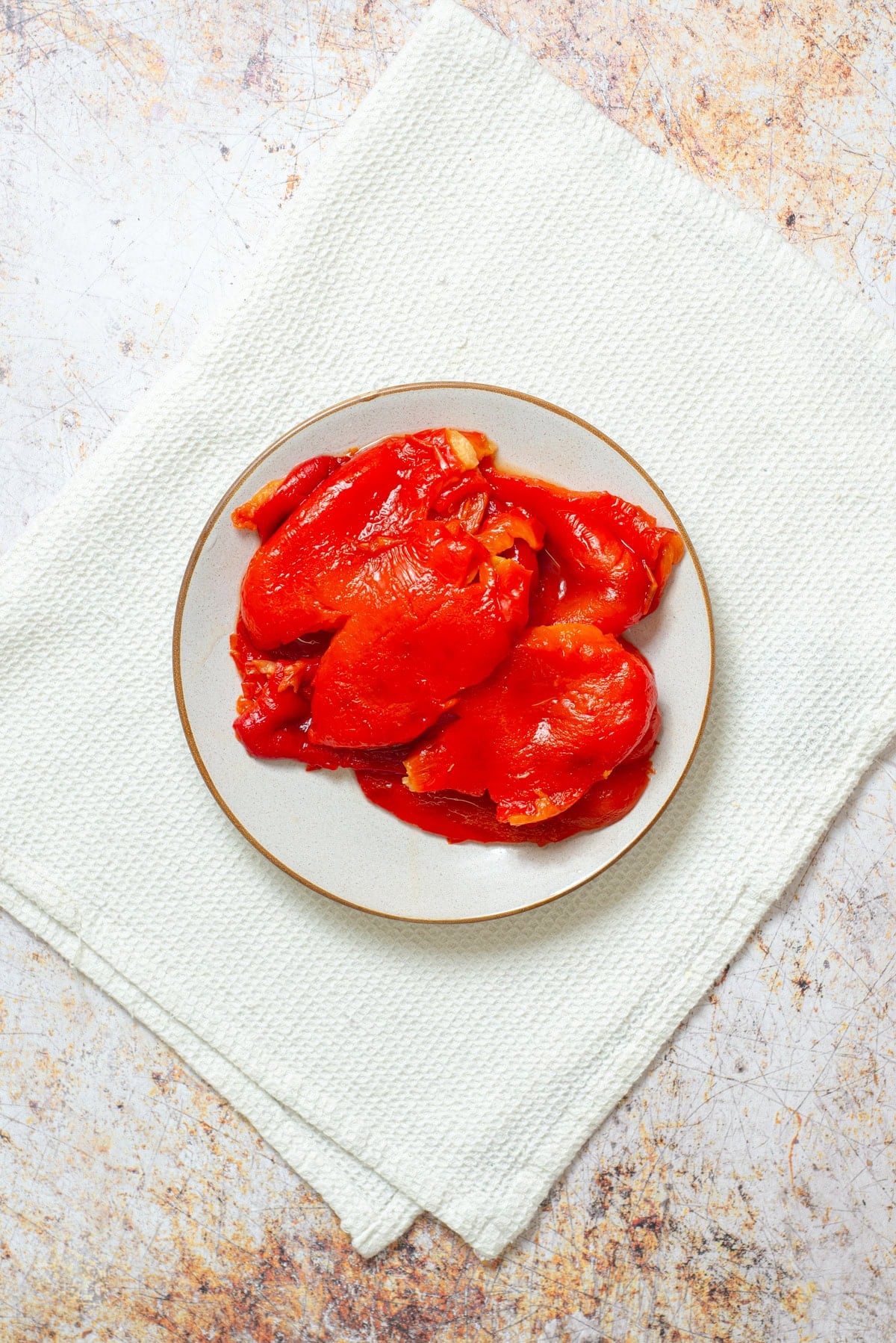 Peeled roasted red peppers on a plate.