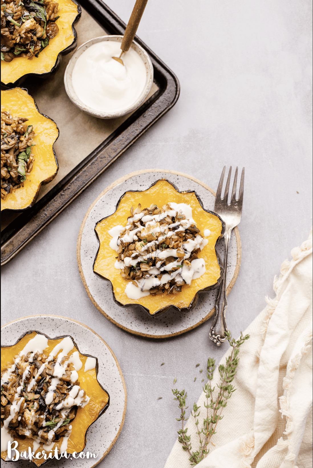 Overhead view of Mushroom & Wild Rice Stuffed Acorn Squash filled with different vegetables and has a drizzle of lemon tahini sauce on top.