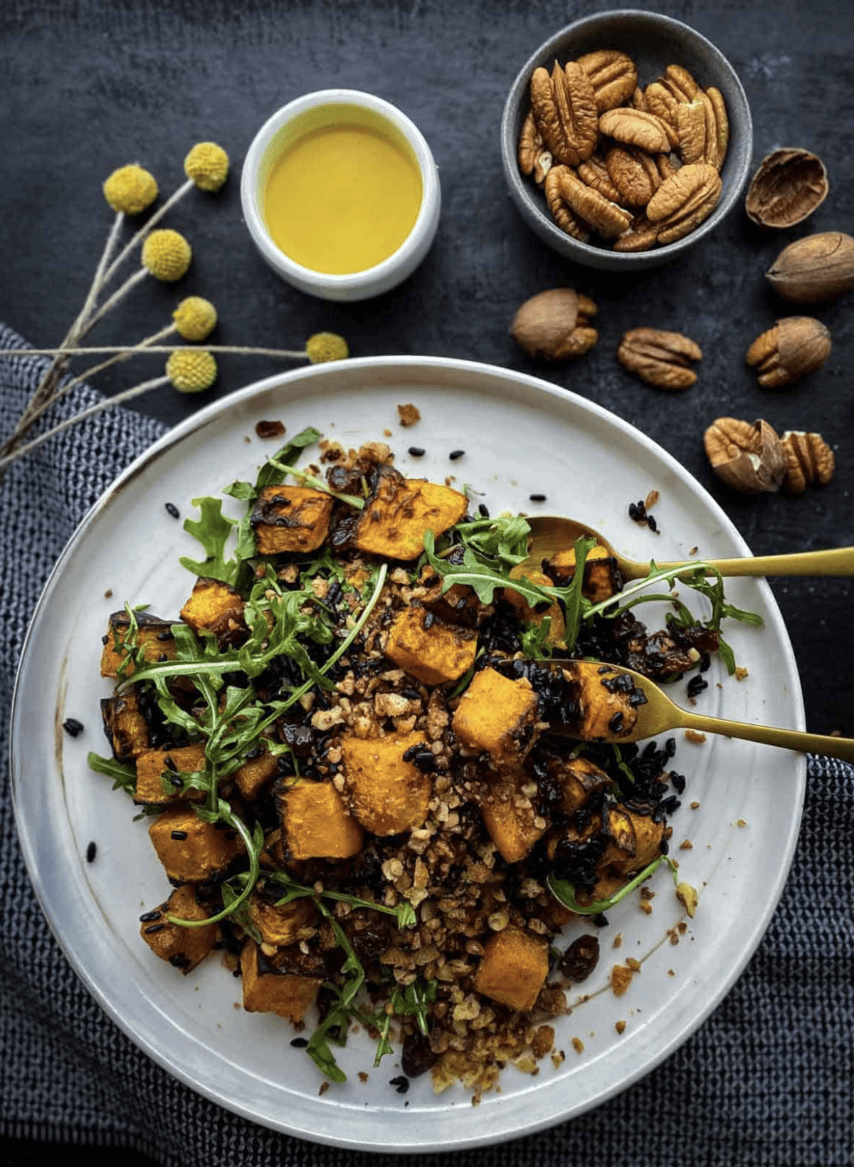 Overhead shot of Butternut Squash Salad with maple orange dressing and pecans on the side.