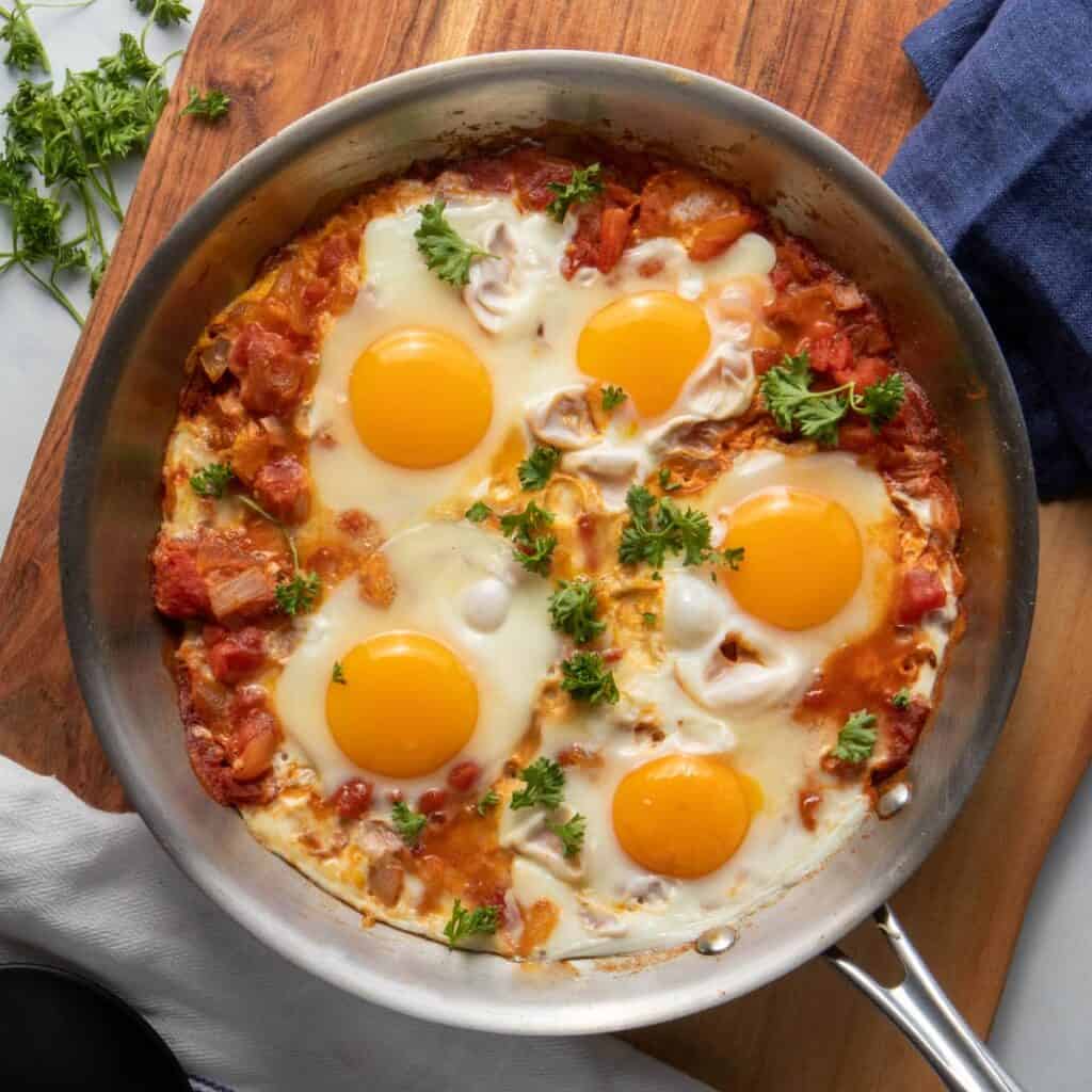 Moroccan shakshuka with delicious eggs, avocados and parsley