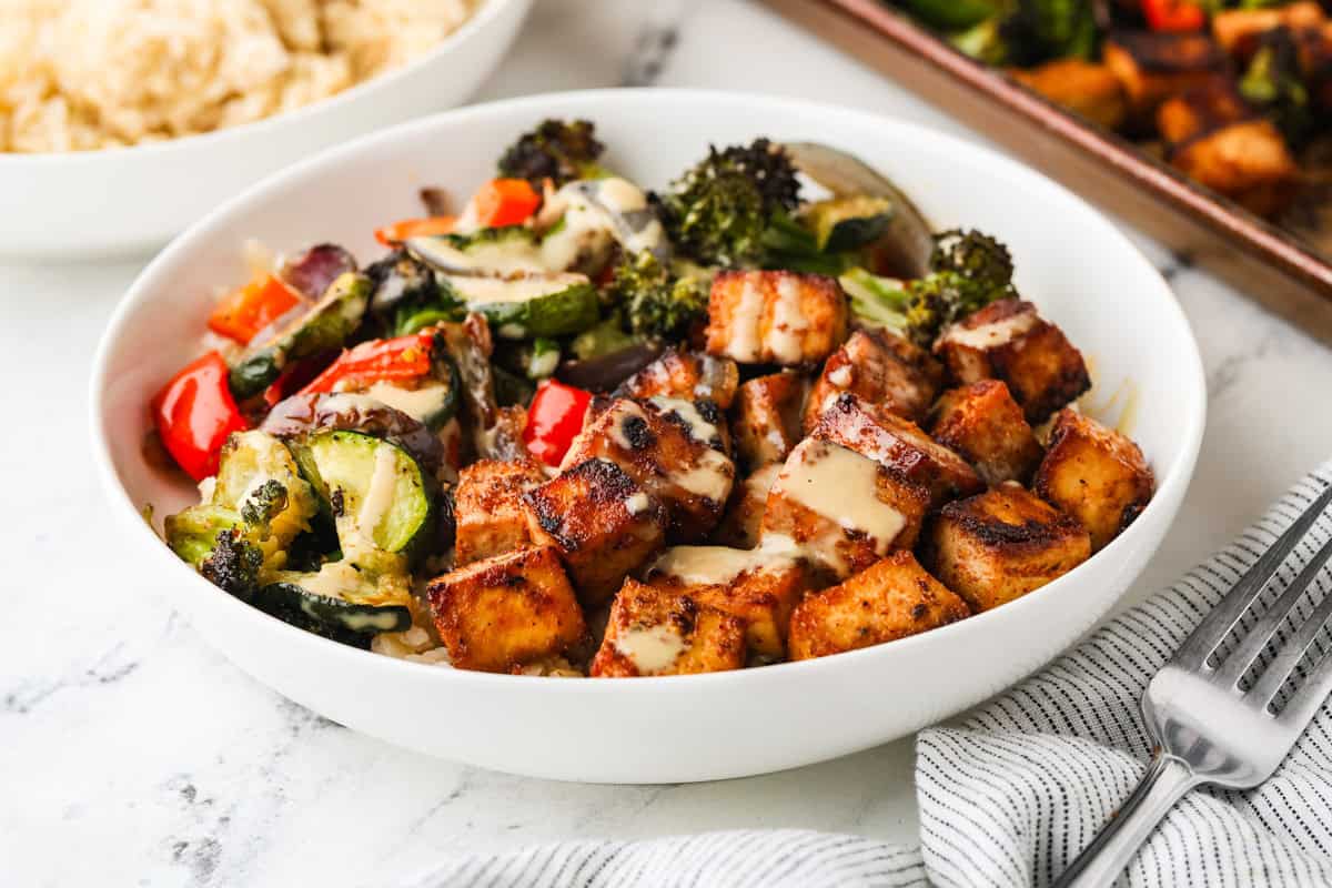A close up image of sheet pan tofu and veggies served in a bowl.