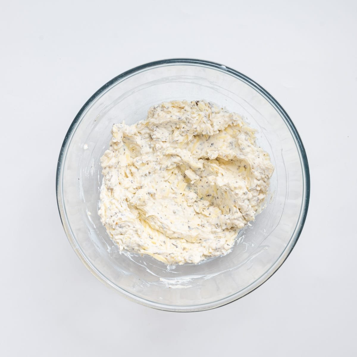 An image of the ricotta cheese mixture, mixed together ina a glass bowl.