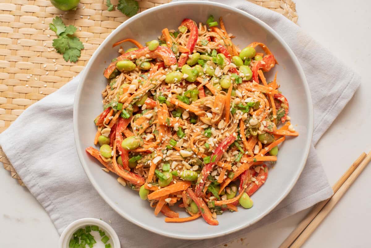 An overhead image of spicy peanut edamame noodles on a plate.