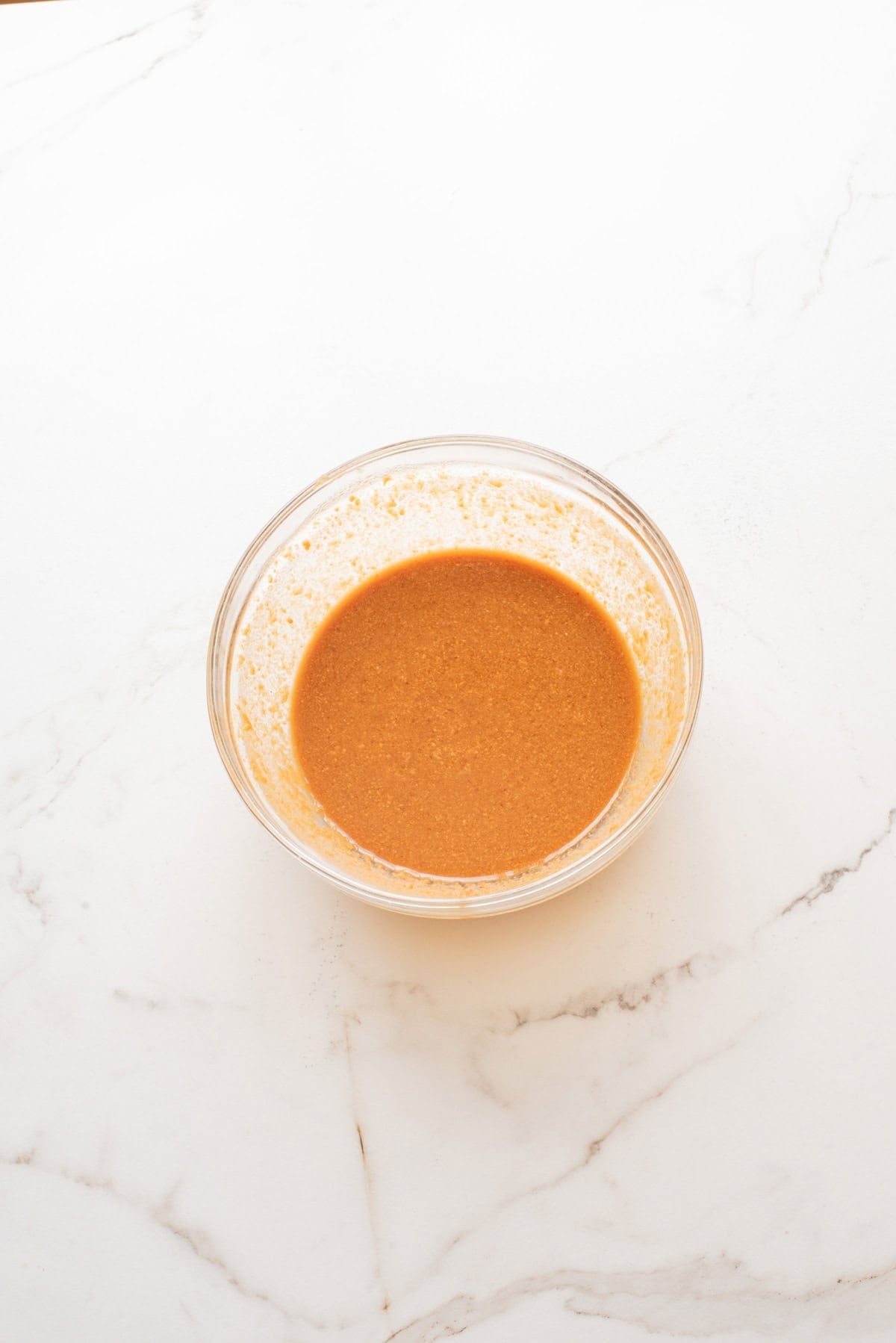 An overhead image of whisking the sauce together in a small bowl.