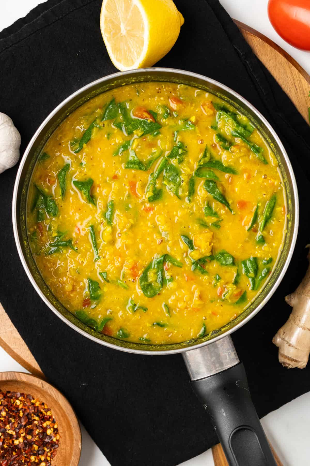 An overhead image of cooked spinach dal in a skillet, ready to be served.