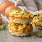 A close up image of spinach and cottage cheese muffins stacked together.