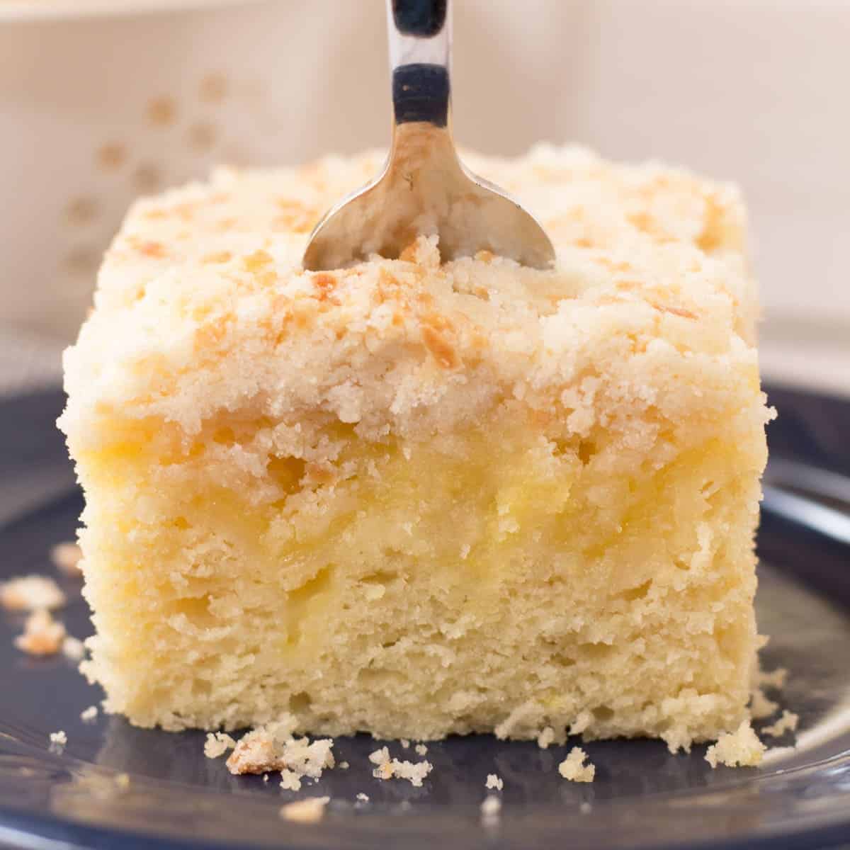 A close-up view of lemon curd coffee cake with fork on top.